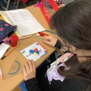 Schülerin schreibt Postkarte an Putin.