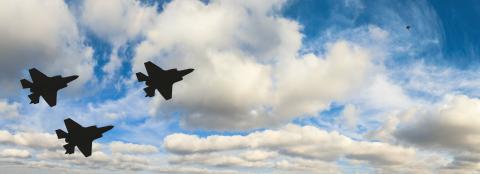 Silhouette von drei Kampfjets vor Wolken am Himmel