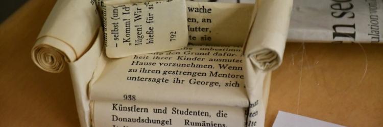 Ein Miniatur-Papiersofa aus Zeitungspapier